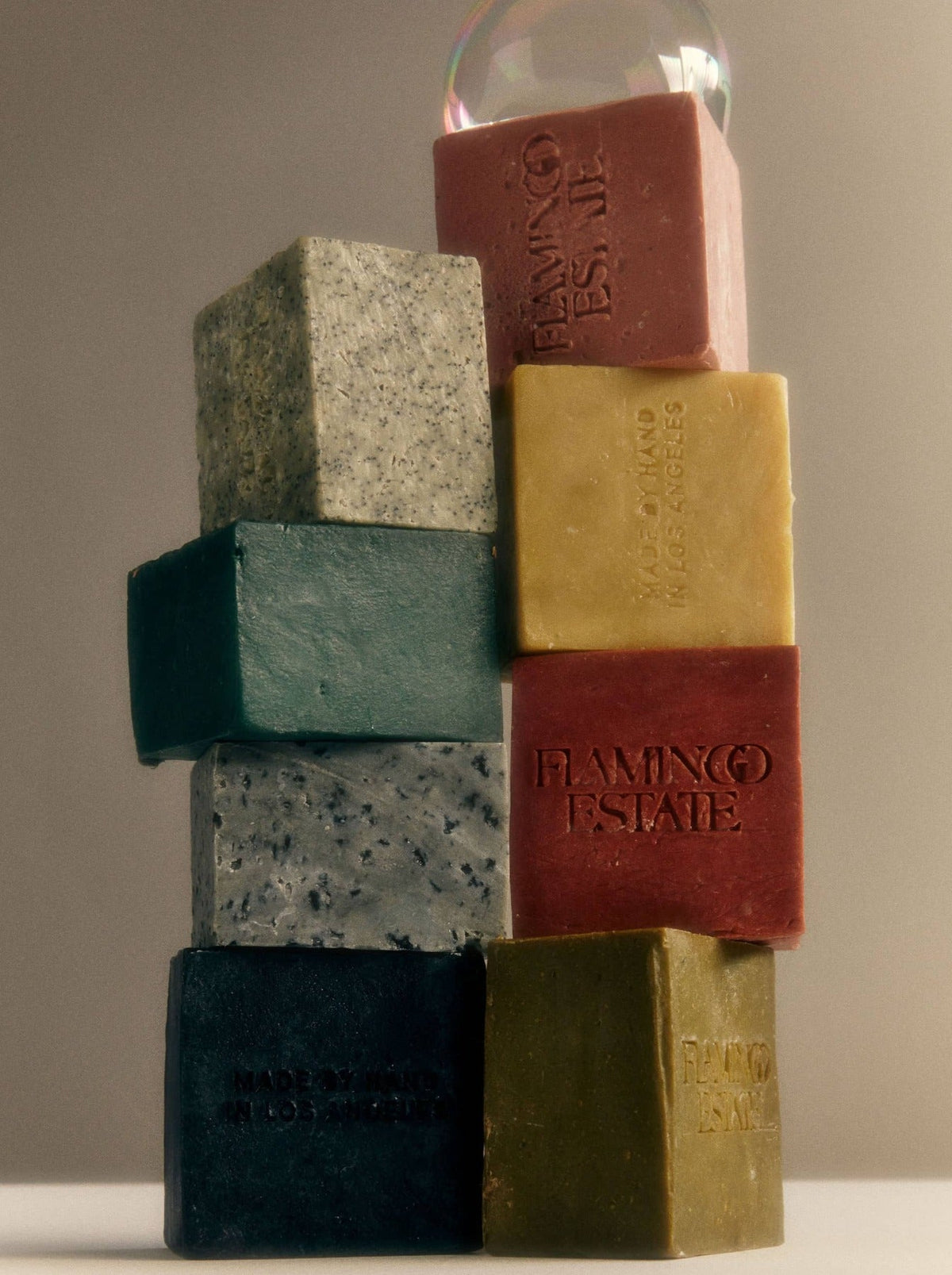 Stacked colorful soap bars, including shades of red, yellow, and blue.