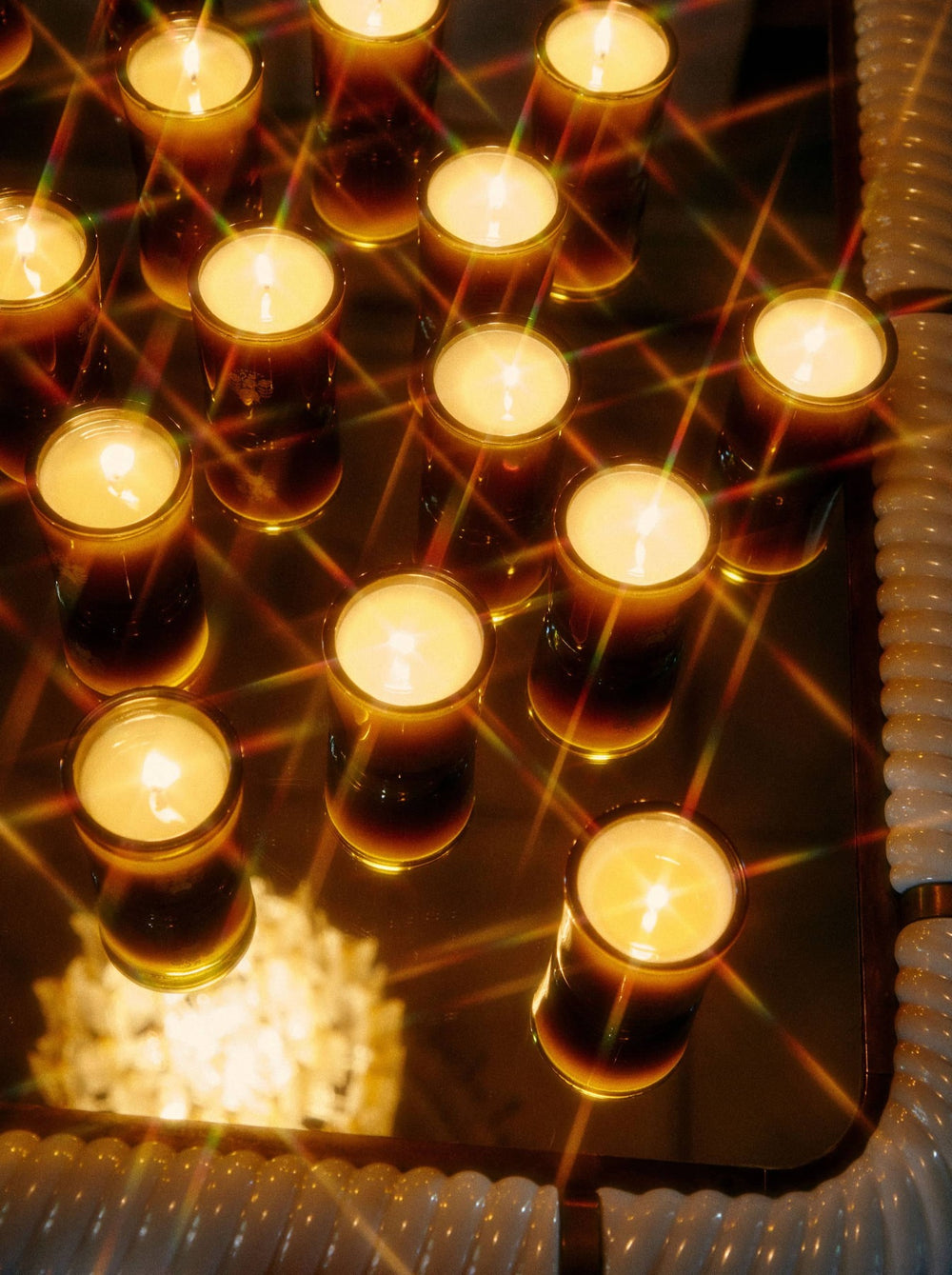 Candles arranged in rows glow softly.