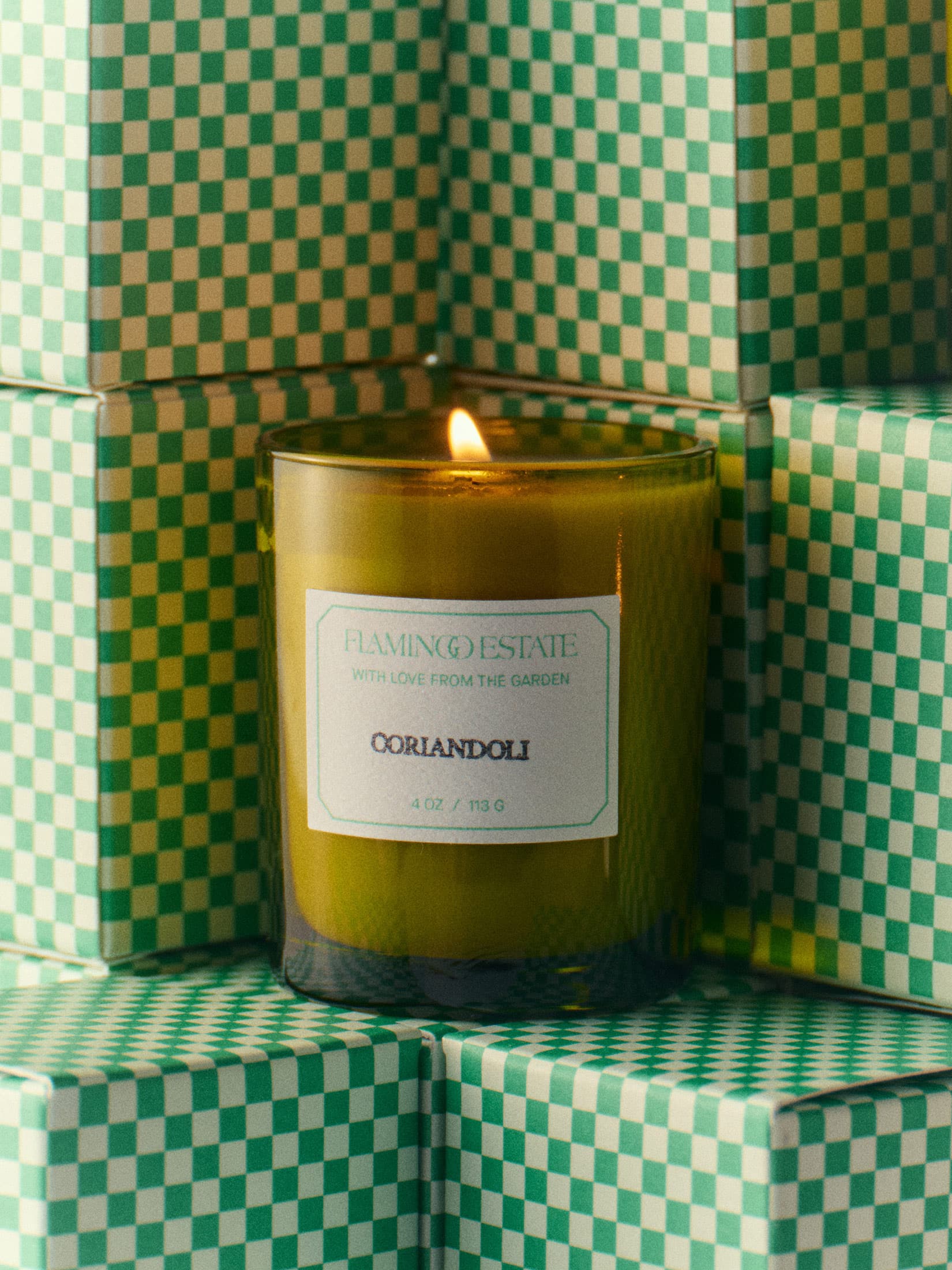 A lit green candle labeled 