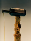 Creative display of a bottle of Flamingo Estate Heritage olive oil pouring onto a stacked tower of assorted bread slices.