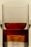 A glass filled with golden Garlic Infused Olive Oil from Flamingo Estate.