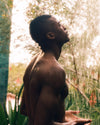 A person stands with eyes closed, facing upward.
