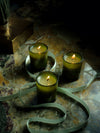Three lit candles from the Mini Three Sister Set by Flamingo Estate, arranged on a marbled surface with a branded ribbon